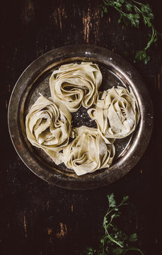 Homemade fresh pappardelle pasta on old fashioned silver plate