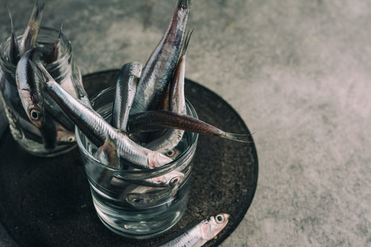 fresh anchovies, in the jar with water, detail. Grunge background.