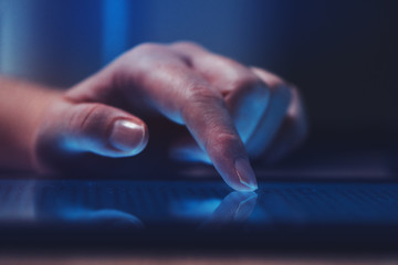 Extreme close up of female finger using digital tablet computer