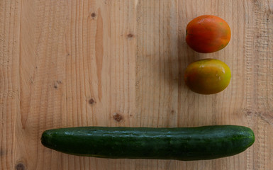 cucumber and tomatoes on wooden background