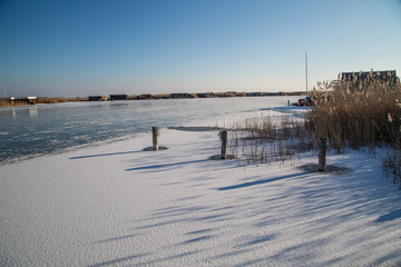 Gefrorener Neusiedler See mit Eisschollen und Eisläufern