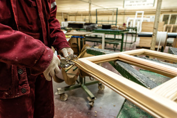 The worker cuts the insulation with a pair of scissors on the window