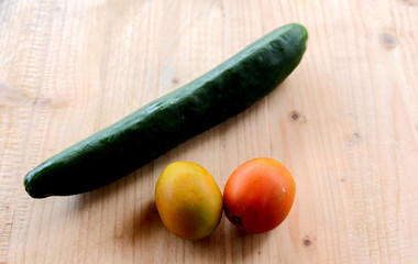 cucumber and tomatoes on wooden background