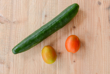 cucumber and tomatoes on wooden background
