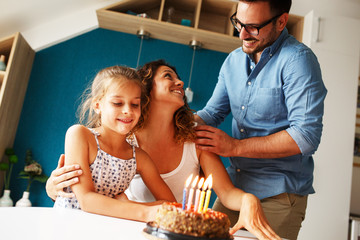 Mother's birthday.Husband and daughter surprise they mother and wife with birthday cake .