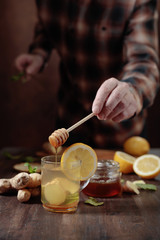 Ginger tea with honey , lemon and mint on old wooden table .