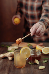 Ginger tea with honey , lemon and mint on old wooden table .