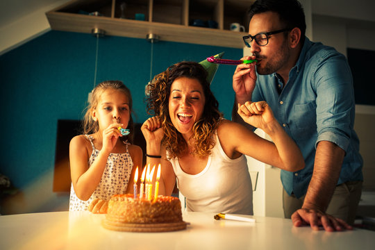 Mother's birthday.Husband and daughter surprise they mother and wife with birthday cake .