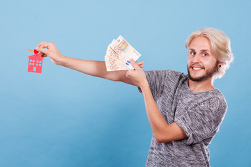 Man holding money and keys to house
