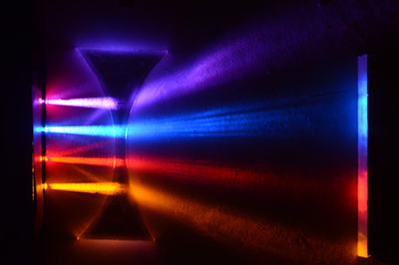 Light beams in colorblind-friendly colors pass trough a concave demonstration lens, the influence on the beams can be seen on the screen
