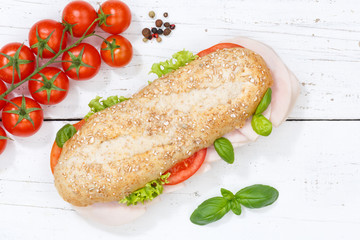 Sandwich Baguette Vollkorn Brötchen belegt mit Schinken von oben auf Holzbrett