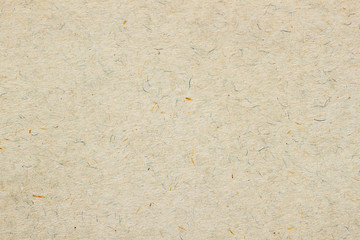 Texture of old organic light cream paper. Recyclable material with small brown and and blue inclusions of cellulose fragments, stubble, nap, hair. Background for design