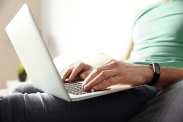 Naklejka premium Young man using laptop at home