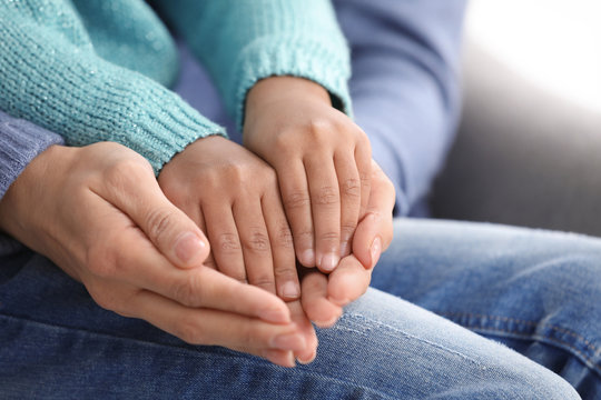 Woman and adopted African-American child, closeup of hands
