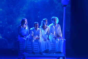 Young actors and Actresses sit on a bench on the stage of the theater