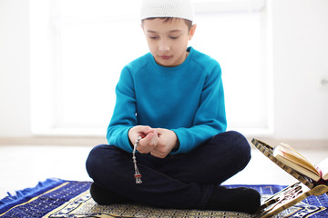Little Muslim boy praying, indoors