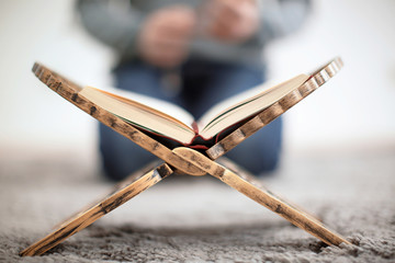 Open holy book of Muslims and blurred man on background