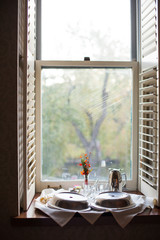 Fototapeta na wymiar Plates on Breakfast Tray in Window of a Bed and Breakfast