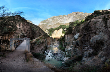 Obraz premium The bridge across the river at the bottom of Colca Canyon in the late afternoon, southern Peru