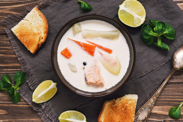 Scandinavian ,Norwegian fish soup on a rustic wooden background. Salmon soup with potatoes, carrots, cream.Close-up, top view