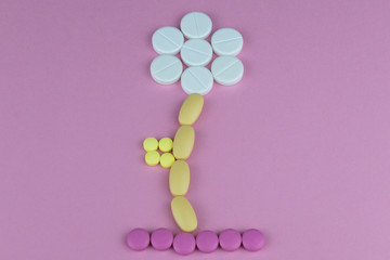 flower of pills on a pink background