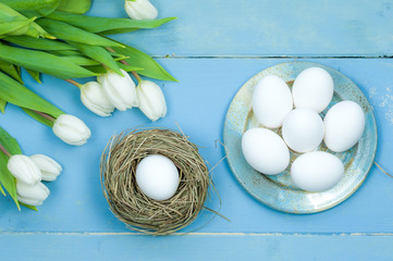 Easter concept. Eggs in a nest on blue wooden table
