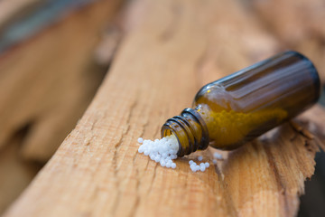 Globulis aus Glas auf Holzhintergrund - Homöopathie - Naturmedizin