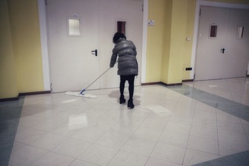 woman sweeps the corridor