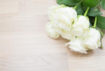 Bunch of beautiful white roses on wooden background.