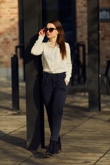 Young pretty woman walk on the street wear glasses and office clothing, spring time