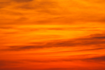 red big sun obscured by clouds near the horizon at sunset or sunrise. The sun is partially seen through the clouds 