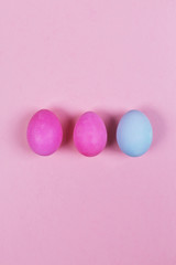 Fototapeta na wymiar Blue and pink eggs on pink background. Top view