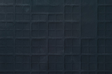 Texture of Ceramic Tile with Checkered Embossing. Black Wall Background