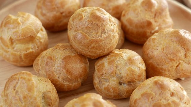 fresh baked cream puff or profiterole or choux creme a pastry ball with sweet and moist filling whipped cream.