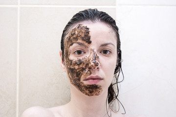 Caucasian model between age 20-29 years using a coffee face scrub for her face and eye bags.