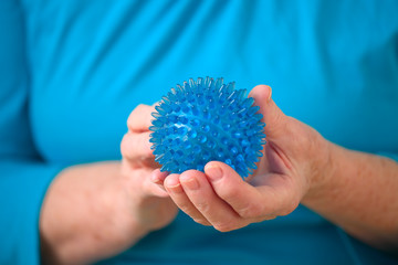Seniorin h&auml;lt einen Igel- Ball