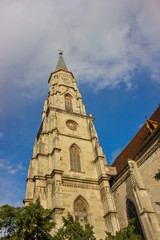 Fototapeta na wymiar Gothic architecture of Church St. Michael in Cluj-Napoca, Romania with partly cloudy blue sky background