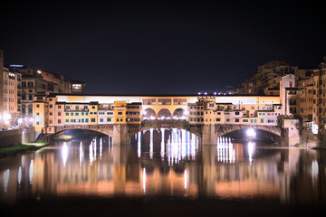 Fototapeta na wymiar Night view of Ponte Vecchio bridge over Arno River with water reflection in Florence,Tuscany, Italy