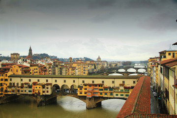 Ponte Vecchio bridge over Arno River with dark cloudy sky background in Florence,Tuscany, Italy - view from Uffizzi Galleries