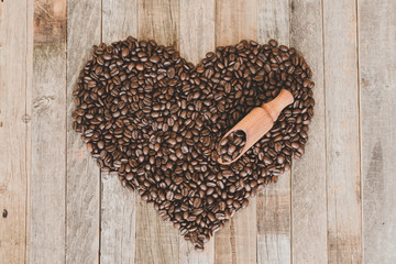Coffee beans in a shape of heart on wooden background
