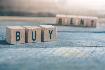 Macro Of The Words Buy And Rent Formed By Wooden Blocks On A Wooden Floor