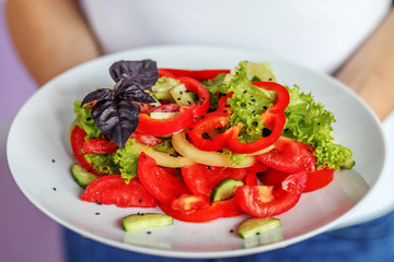 Vegetable salad of tomatoes, pepper, lettuce and sesame salad. The concept is healthy food, diet, vegetarianism, weight loss.