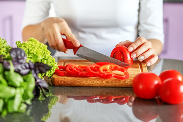 The hostess slicers vegetables in the kitchen. Making vegetarian food. The concept is healthy food, diet, vegetarianism, weight loss.