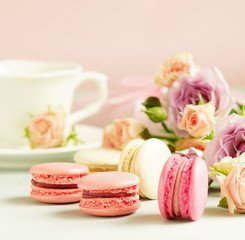 macaroons in pastel colors with flowers on a pale pink background.Holiday background.copy space