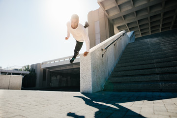 Man doing parkour wall spin in urban space