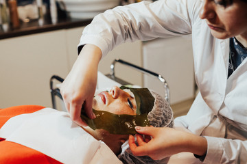 algae face mask. Woman on seaweed wrap at a spa salon. Woman is having a procedure in cosmetology cabinet © Helga Bragina
