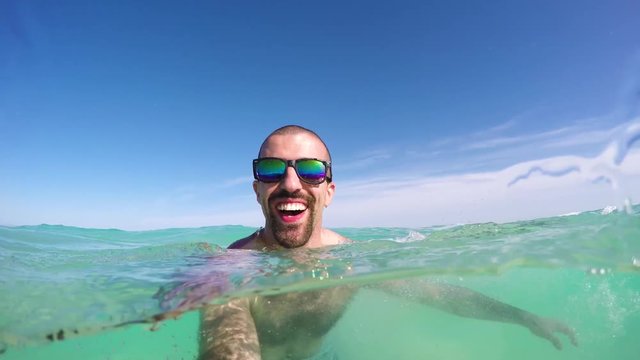 Man taking a selfie part underwater at seaside in Spain