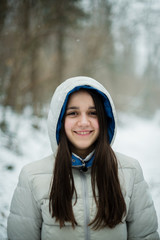 portrait of an 11-year-old girl outside under a snowfall, dressed in a down jacket, a windbreaker © Emanuele Capoferri