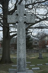 Celtic cross on grave, memorial grave marker carved stone cross in graveyard