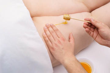 Obraz na płótnie Canvas Anti-cellulite honey legs massage for healthy and smooth skin. Spa, wellness, health care concept